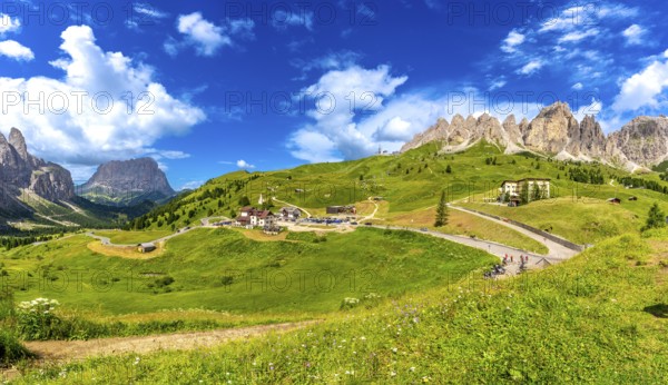Stunning landscape of gardena pass in the italian dolomites, featuring lush meadows, winding roads,