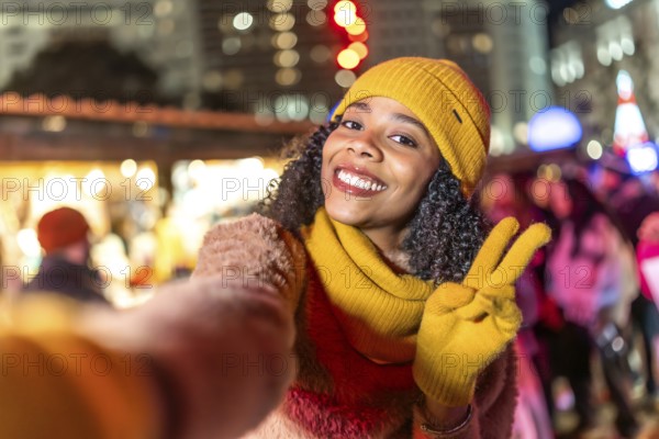 Smiling woman wearing winter clothes showing victory sign holding boyfriend's hand enjoying