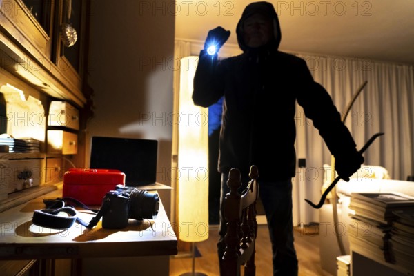 Symbolic image of a burglary, perpetrator has broken into a flat from the garden side and is