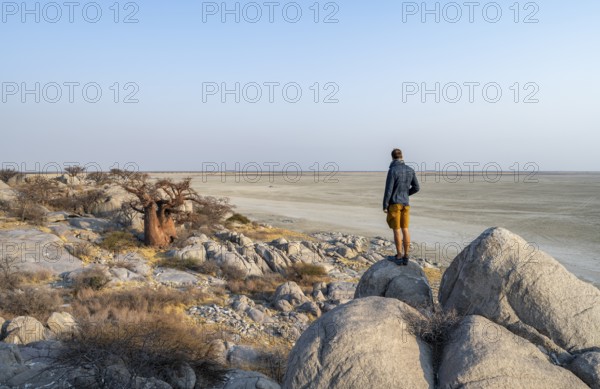 Tourist looking over the salt pan, African baobab or monkey bread tree (Adansonia digitata),