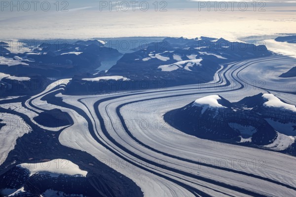 Aerial view of glaciers, glacier tongues and icy mountains on the coast, sunny, East Greenland,