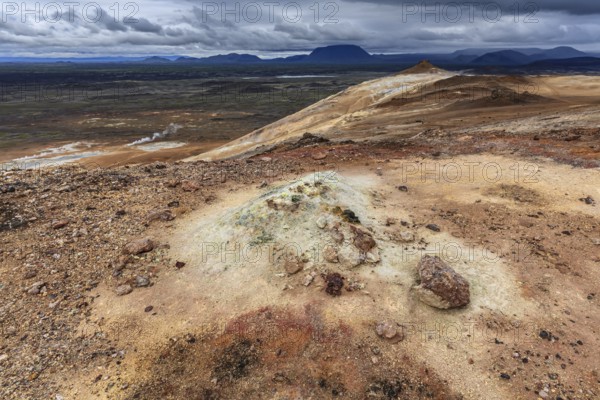 Geothermal field and sulphur springs in front of mountain landscape, clouded, Namafjall, Myvatn,