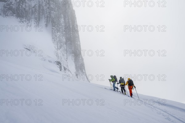 Dramatic atmosphere, Ski tourers, Snowy mountain landscape, Bernese Alps, Bernese Oberland,