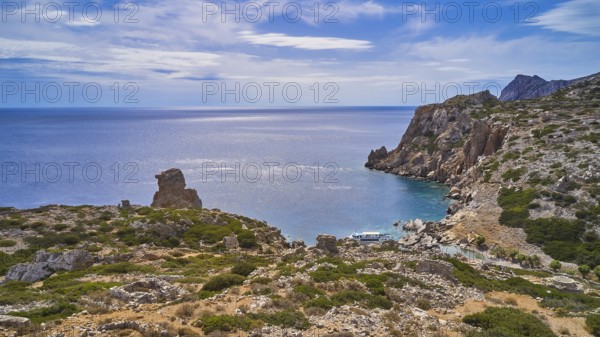 Palatia Beach, Palatia, coastal landscape with rocky views and calm sea under an expansive sky,