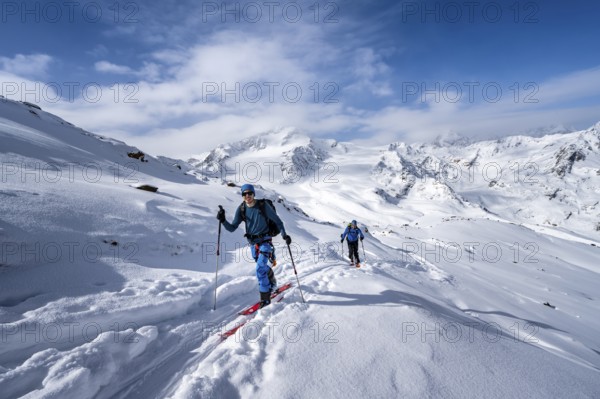 Ski tourers in a snow-covered mountain landscape, mountain peak Monte Cevedale and glacier