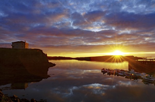 Sunset over the sea with reflecting clouds and a calm coast, Stykkisholmur, Snaefelsnes, Iceland,