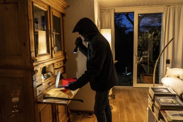 Symbolic image of a burglary, perpetrator has broken into a flat from the garden side and is
