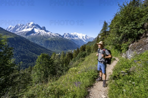 Mountaineer on hiking trail, mountain panorama with glaciated mountain peaks, Aiguille Verte with