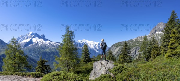 Mountaineer standing on rocks, mountain panorama with glaciated mountain peaks, Aiguille Verte with