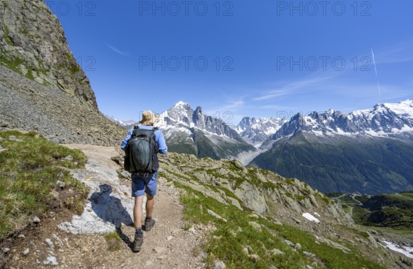 Mountaineer on a hiking trail in front of a mountain landscape, view of the mountain peaks Aiguille