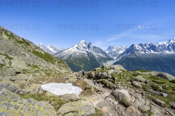 Mountaineer on a hiking trail in front of a mountain landscape, view of the mountain peaks Aiguille