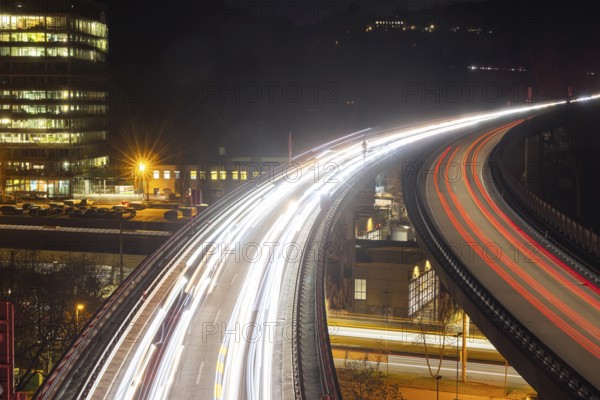 Federal road B14 at night, road bridge with traffic and light lanes. On the left the building of