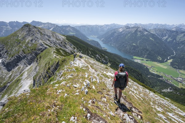 Mountaineer on the summit ridge of the Unnütz, behind Achensee and summit of the Seekarspitze