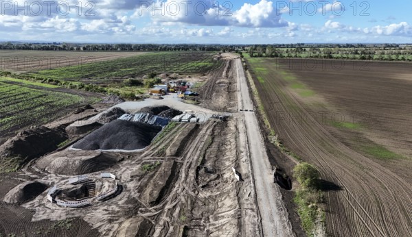 Construction vehicles are parked at an access road under construction to the High Tech Park at the