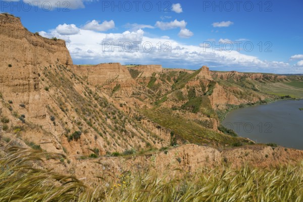 Panorama einer felsigen, trockenen Landschaft mit einem Fluss und blauem Himmel mit Wolken,