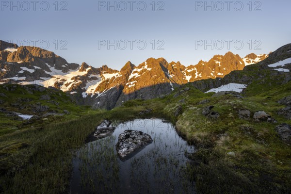 Rocky mountain peaks with reflection, small pond in moor landscape at Trollfjord Hytta, mountain