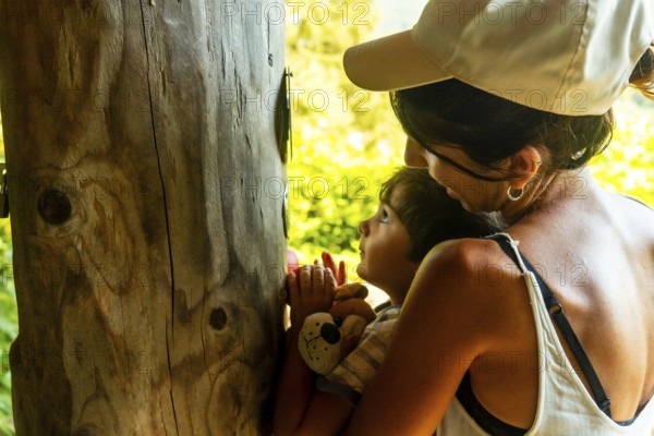 Mother and son smelling a tree in a sensory park to enjoy nature and the senses, Black Forest,