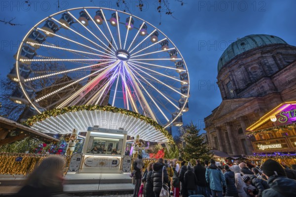 Ferris wheel at the winter village, Christmas market at dusk, St Elisabeth's Church on the right,