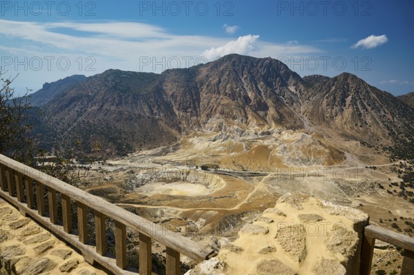 Viewpoint overlooking vast volcanic landscape and majestic mountains under sunny skies, volcanism,