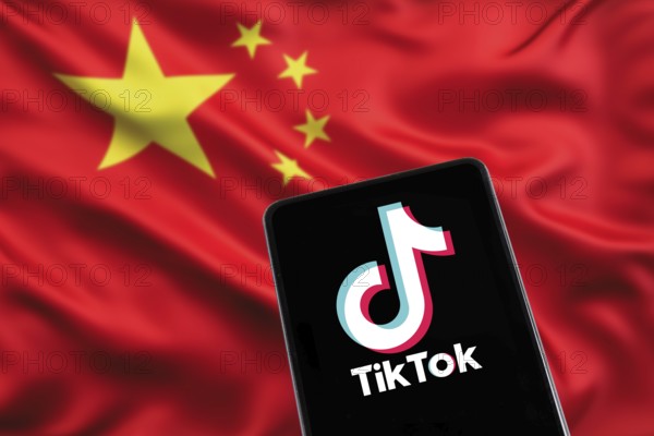 TikTok logo from China with Chinese flag social media on a mobile phone in Stuttgart, Germany,