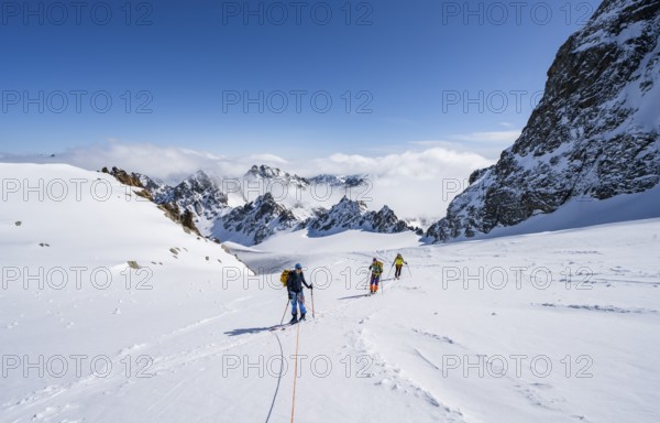 Ski tourer with rope, rope team on the Vadret da Porchabella glacier on the ascent to the summit of