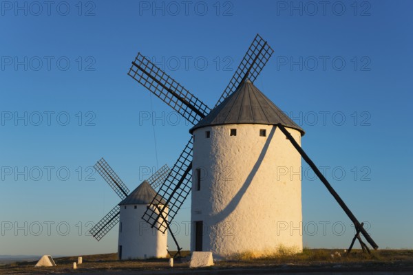 Two large white windmills in the morning sun with long shadows, Campo de Criptana, Ciudad Real