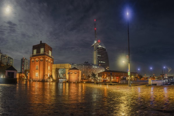 View of the old bascule bridge, the Klimahaus and a hotel in Bremerhaven at night, Bremerhaven,