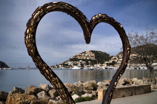 View through a heart of stones to the harbour of Port d'Andratx with marina, Majorca, Balearic