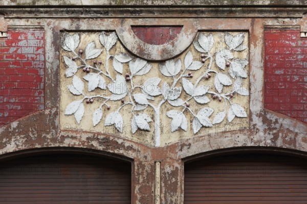 Facade decoration on a Wilhelminian style house for renovation, branches with cherries, detail,