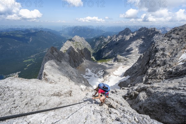 Mountaineer with helmet in a secured via ferrata, Zugspitze via ferrata, ascent to the Zugspitze,