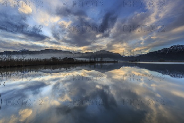 Mountains reflected in a lake at sunrise, cloudy mood, winter, Loisach-Lake Kochel moor, Alpine