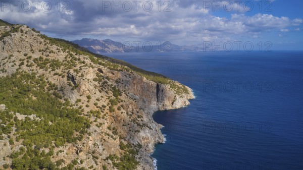 Drone shot, coastal landscape with rocky cliffs, blue sea and cloudy sky, drone shot, rocky coast,