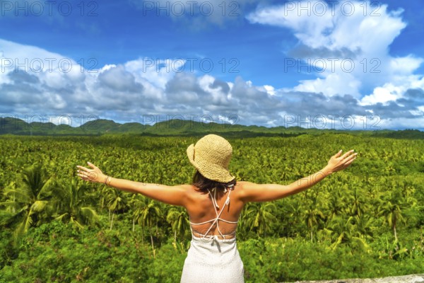 Tourist embracing the stunning view of a vast coconut plantation in siargao island, philippines,