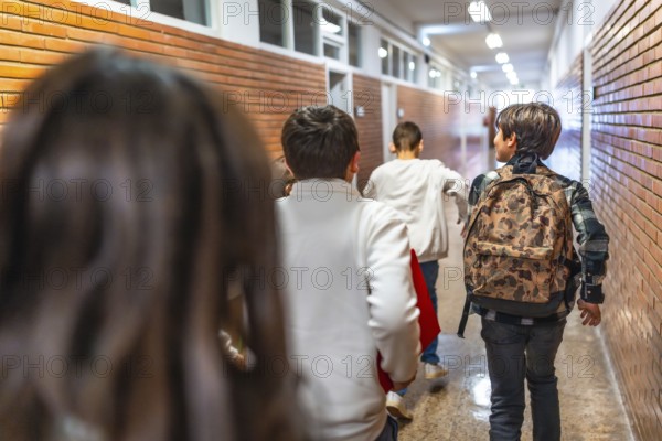 Pupils running down school hallway after class bell rings, eager to get home or to extracurricular