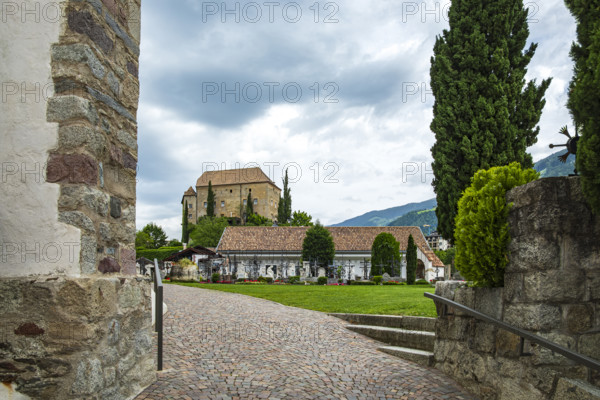 Picturesque cemetery with a view of Scena Castle, on the church hill of Scena above Merano, in the