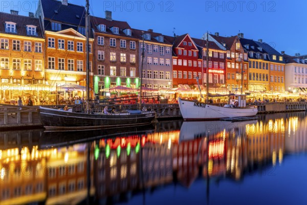Colourful houses, restaurants and historic ships on the Nyhavn canal and harbour at dusk,