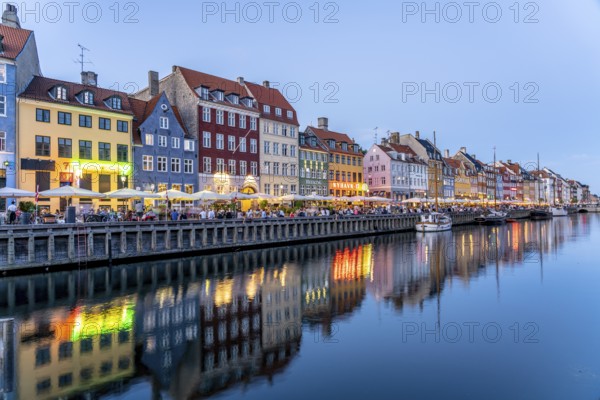 Colourful houses, restaurants and historic ships on the Nyhavn canal and harbour at dusk,