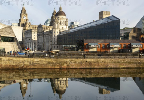 The Three Graces iconic waterfront landmark buildings reflected in water, Canning Dock, Liverpool,