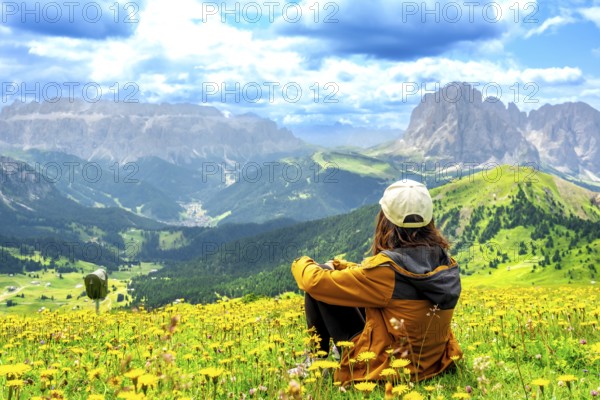 Hiker enjoying the stunning view of the seceda mountains in the dolomites during summer, surrounded
