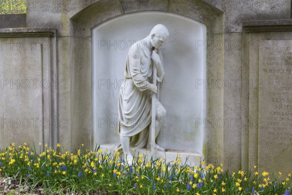 Grave with large figure of a man and spring blossom, Dresden Forest Cemetery, Saxony, Germany,