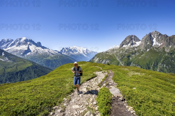 Mountaineer on hiking trail, mountain panorama with glaciated mountain peaks, Aiguille Verte with