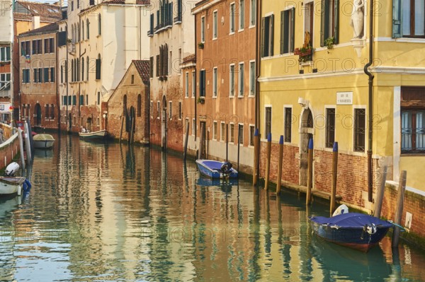 View from 'Casa di otello' over a waterway with boats lying in the water in Venice on a sunny day