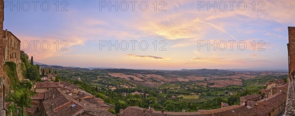 View from Montepulciano into a typical Tuscan landscape in Val d'Orcia with hills, trees, fields,