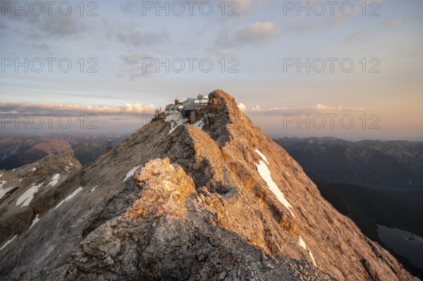 Rocky mountain ridge, summit of the Zugspitze with Zugspitze railway, Jubiläumsgrat, at sunrise,