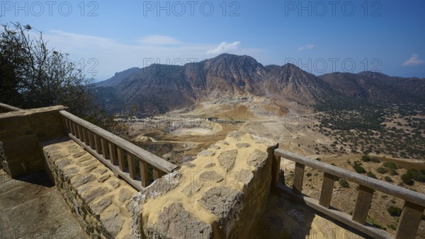 Breathtaking view of volcanic landscape with rocky balustrade and clear sky in the background,