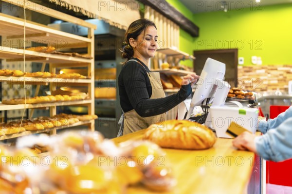Side view photo with copy space of a latin young woman worker preparing bill for a client in an