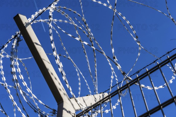 Symbolic image security, S-wire rolls, NATO wire, on a fence top, demarcation of a property,