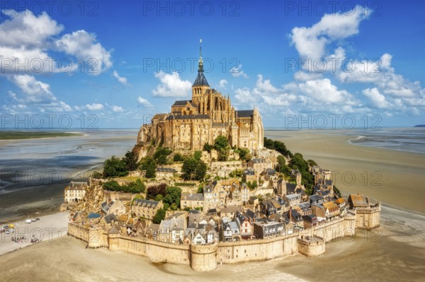 Impressive building complex on an island in a vast sandy landscape under a blue sky, Le