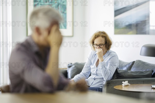 Symbolic photo on the subject of problems in a partnership. An older woman and an older man sitting