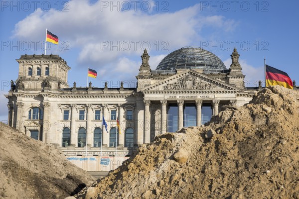 Reichstag building in Berlin Mitte behind Sandbergen due to construction work on the Platz der